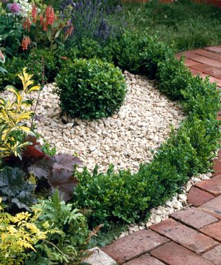 low hedge design with gravel in flower bed