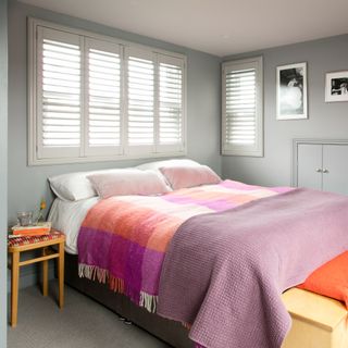 pink and grey bedroom with tartan rug