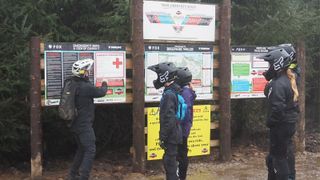 A MTB coach showing safety information to young riders