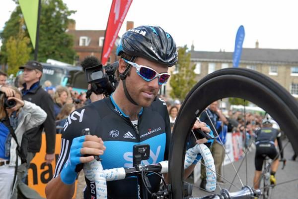 Alex Dowsett wheels his bike to sign on.