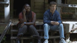 Adebayo and Adrian sitting outside of Chris Smith's cabin in Peacemaker