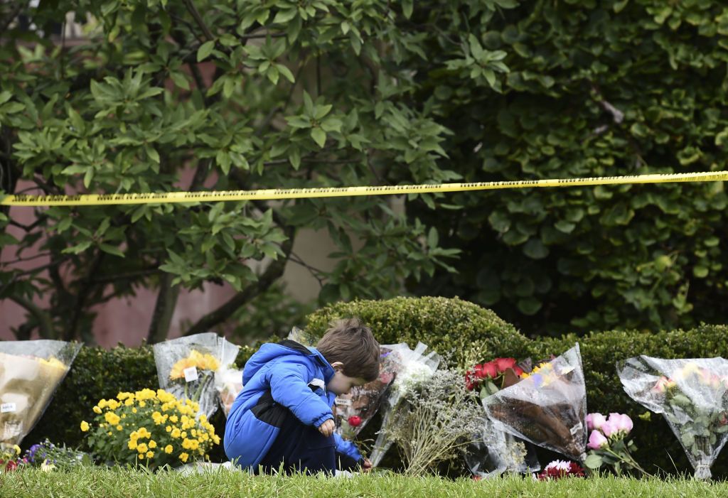 A boy places flowers on October 28, 2018 outside of the Tree of Life Synagogue after a shooting there left 11 people dead in the Squirrel Hill neighborhood of Pittsburgh on October 27, 2018.