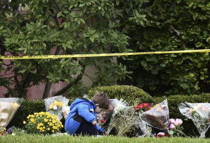 A boy places flowers on October 28, 2018 outside of the Tree of Life Synagogue after a shooting there left 11 people dead in the Squirrel Hill neighborhood of Pittsburgh on October 27, 2018.