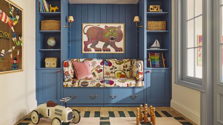 Colorful kid's room with blue painted cabintery, bespoke shelves decorated with toys