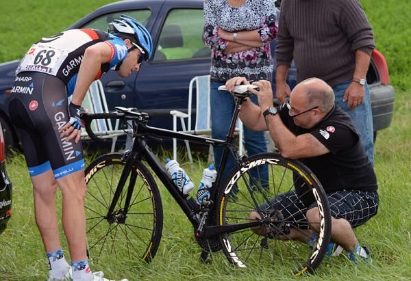 Christian Vande Velde (Garmin-Sharp) has his bike attended to by a team mechanic on a crash-marred stage 6.