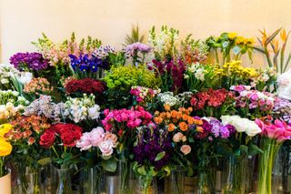 A large flower display at a market with many varieties of flowers.