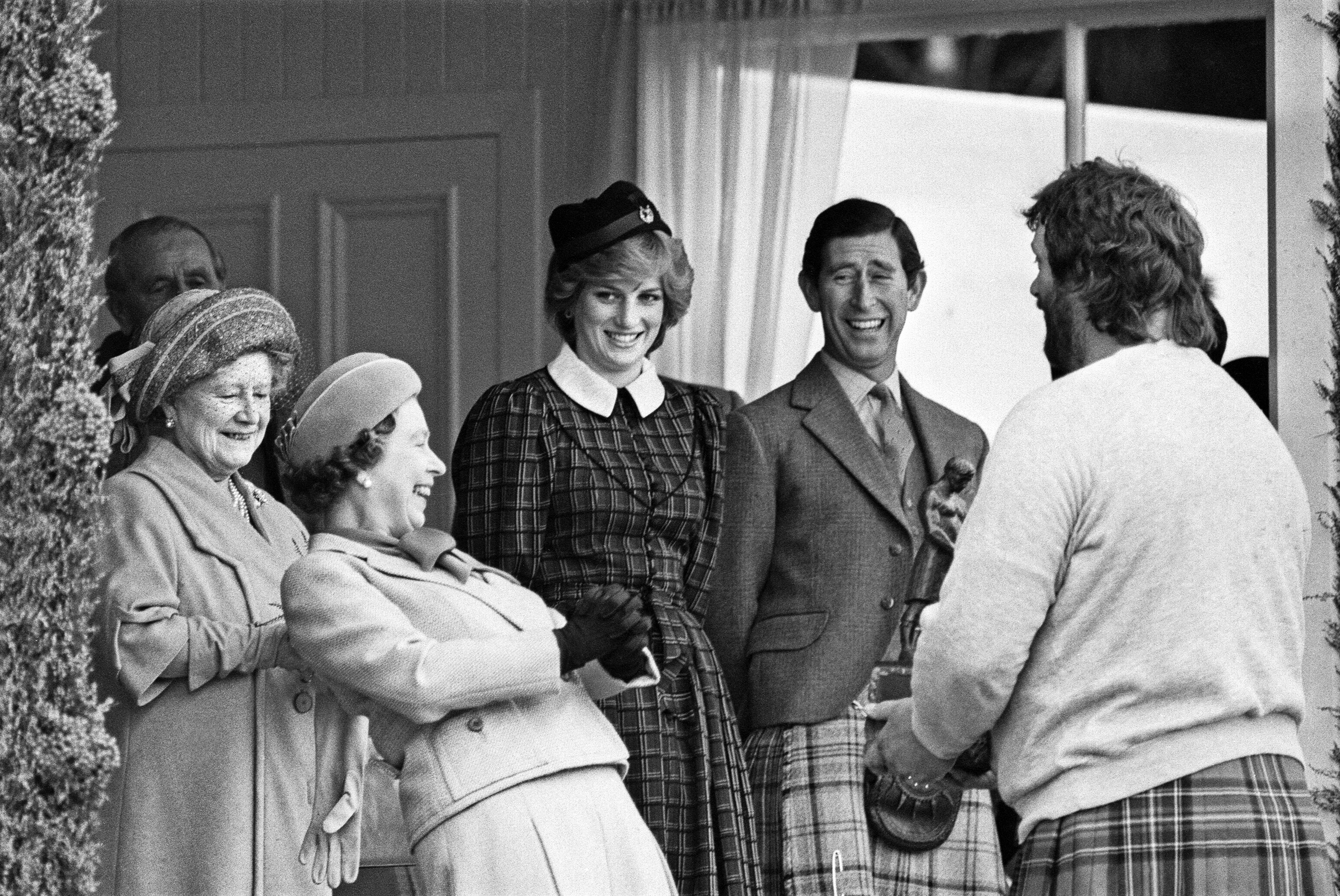 Queen Elizabeth laughing at the Braemar Highland Games next to the Queen Mother and Princess Diana and Prince Charles, who is wearing a kilt