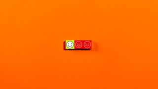 Software buyer's remorse concept image showing a yellow colored happy face with frowning face placed against an orange background.