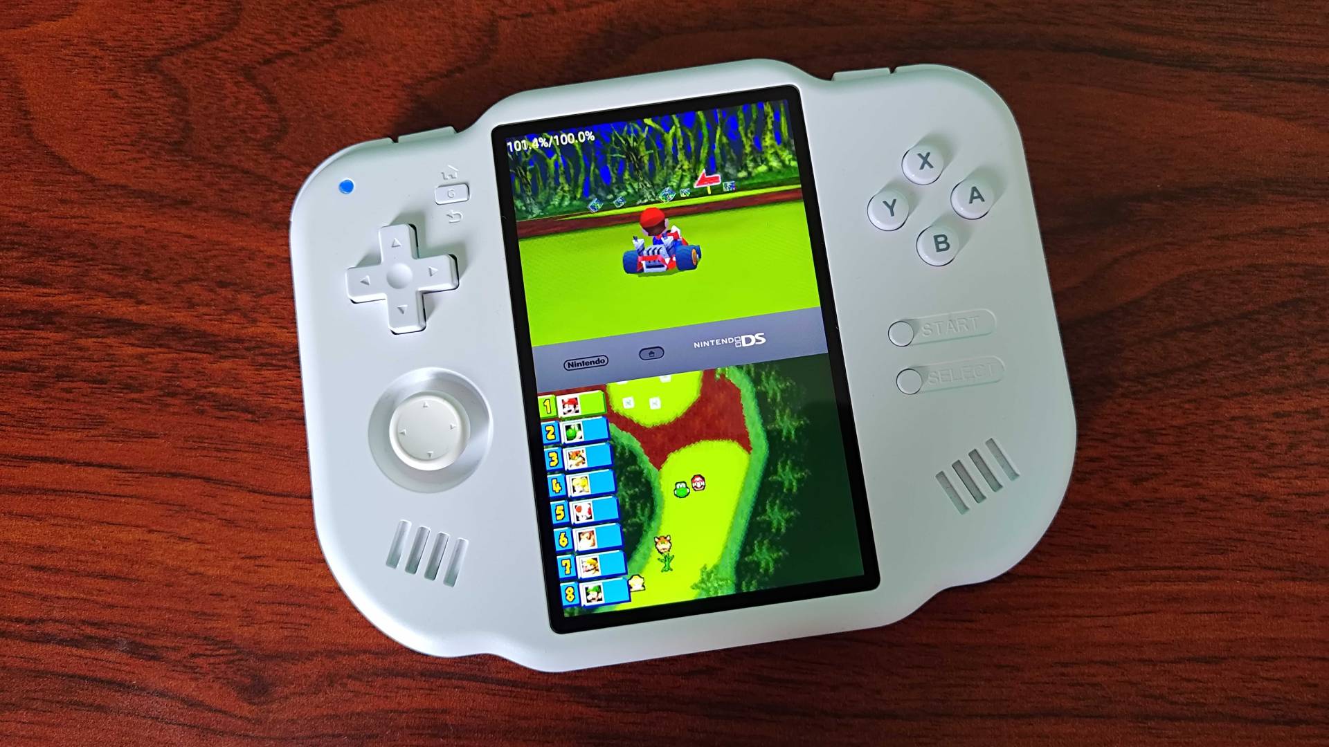 MagicX Zero 40 in white sitting on woodgrain desk running Mario Kart DS.