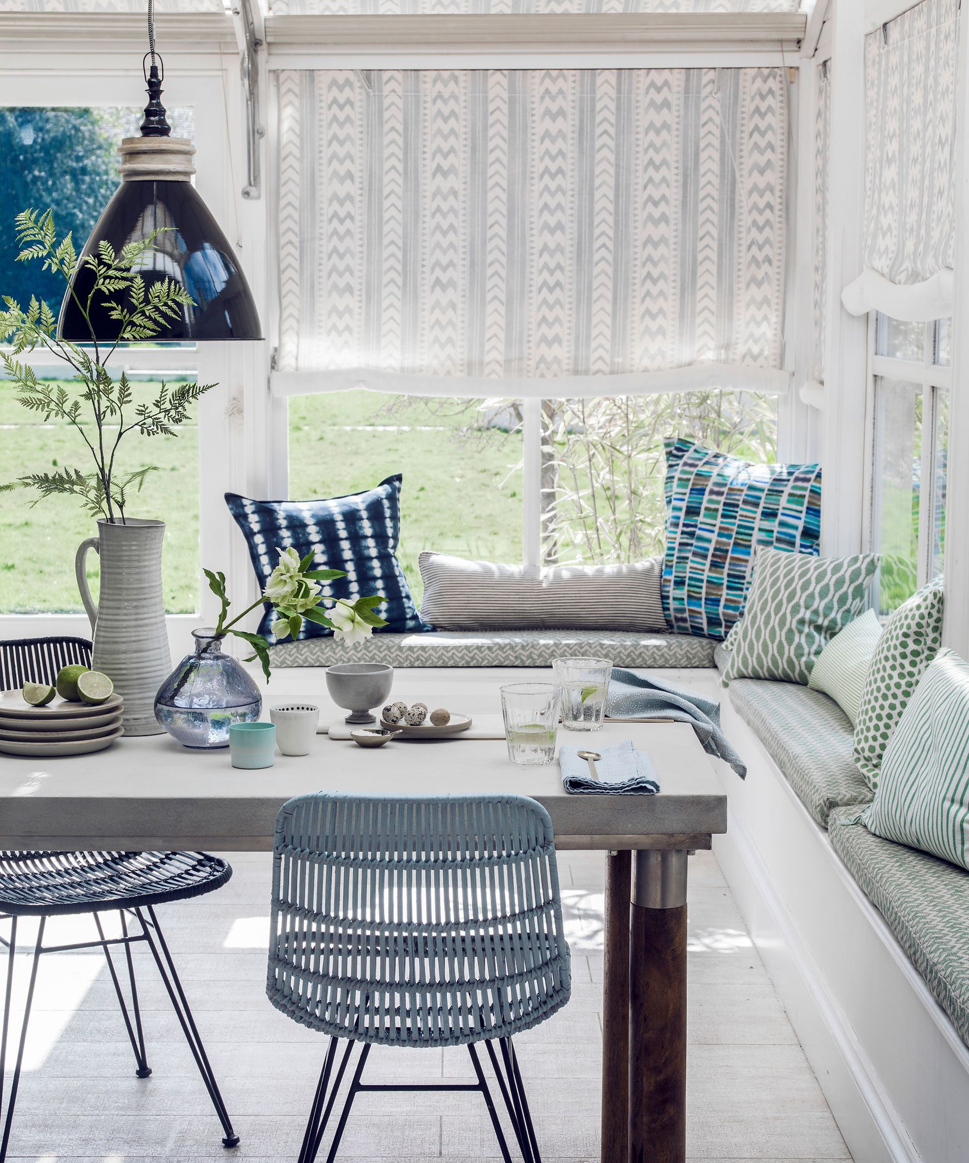 White dining room with window seat and wooden table