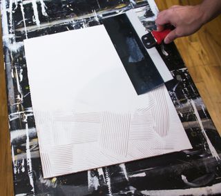 A taping knife smoothing gesso
