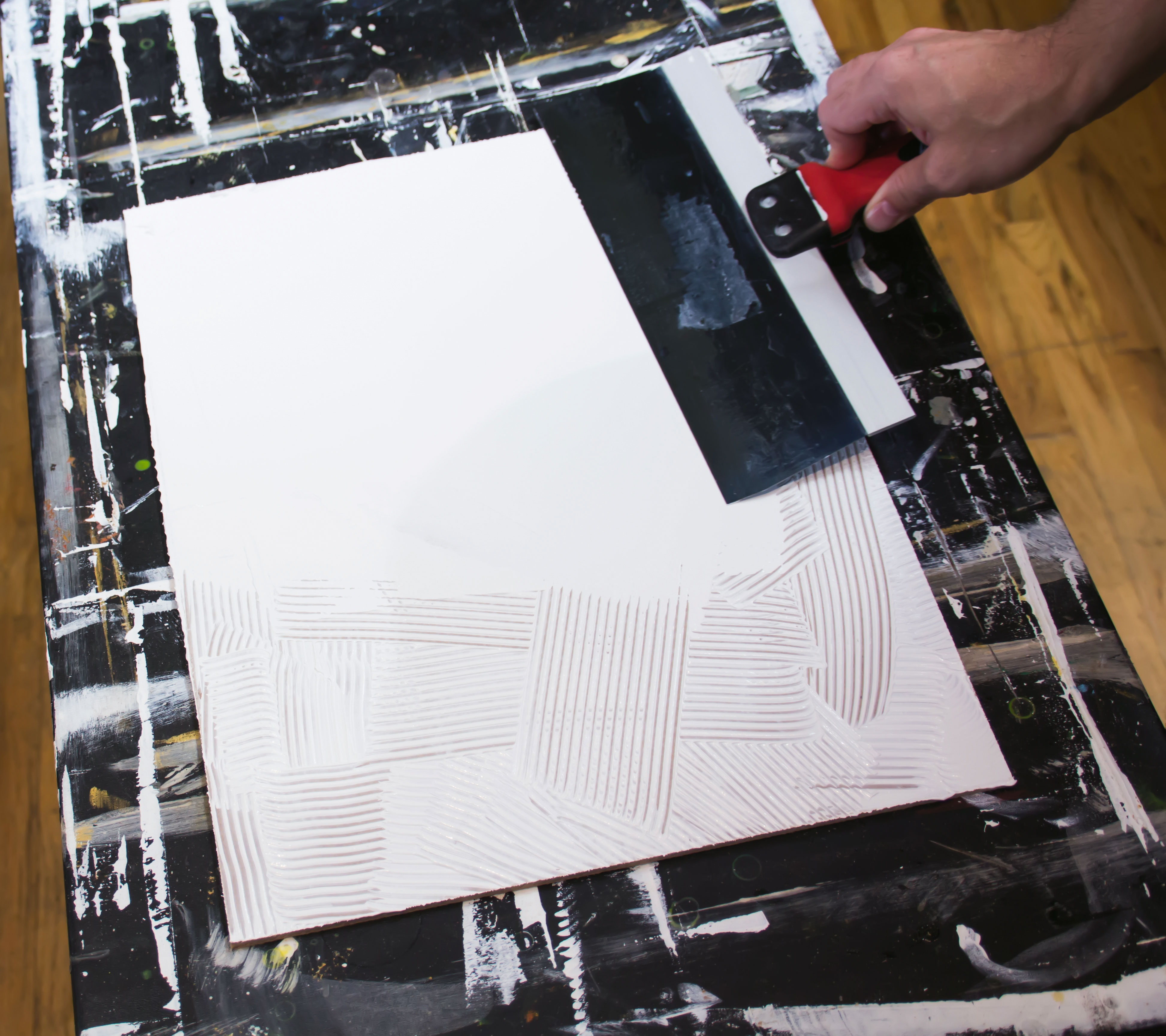 A taping knife smoothing gesso