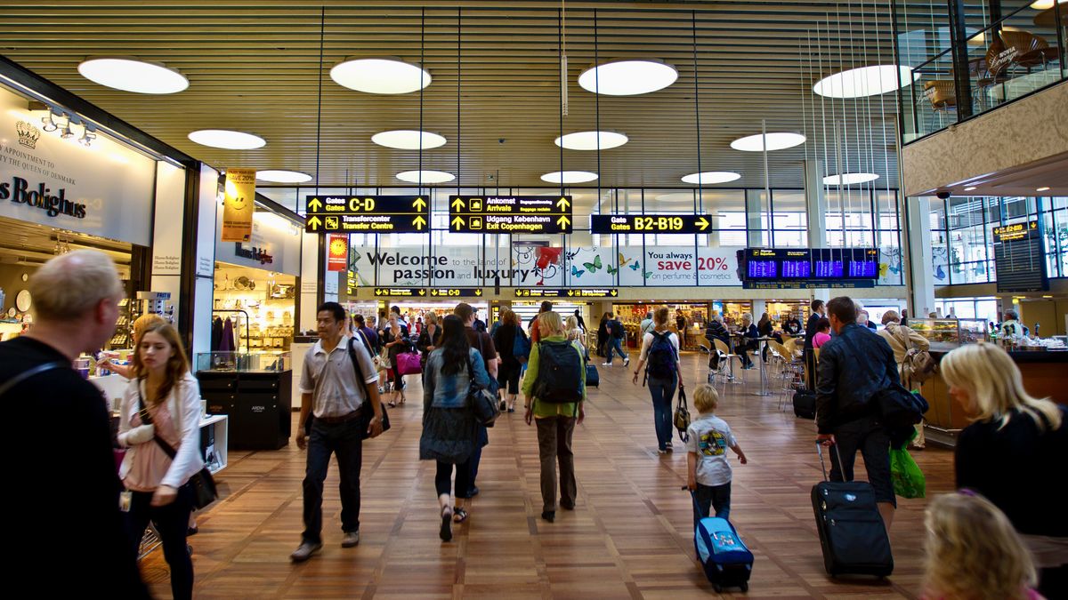 People walking through the Copenhagen Aiport with their luggage