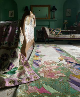 A green living room with patterned chaise lounges and brightly patterned carpet