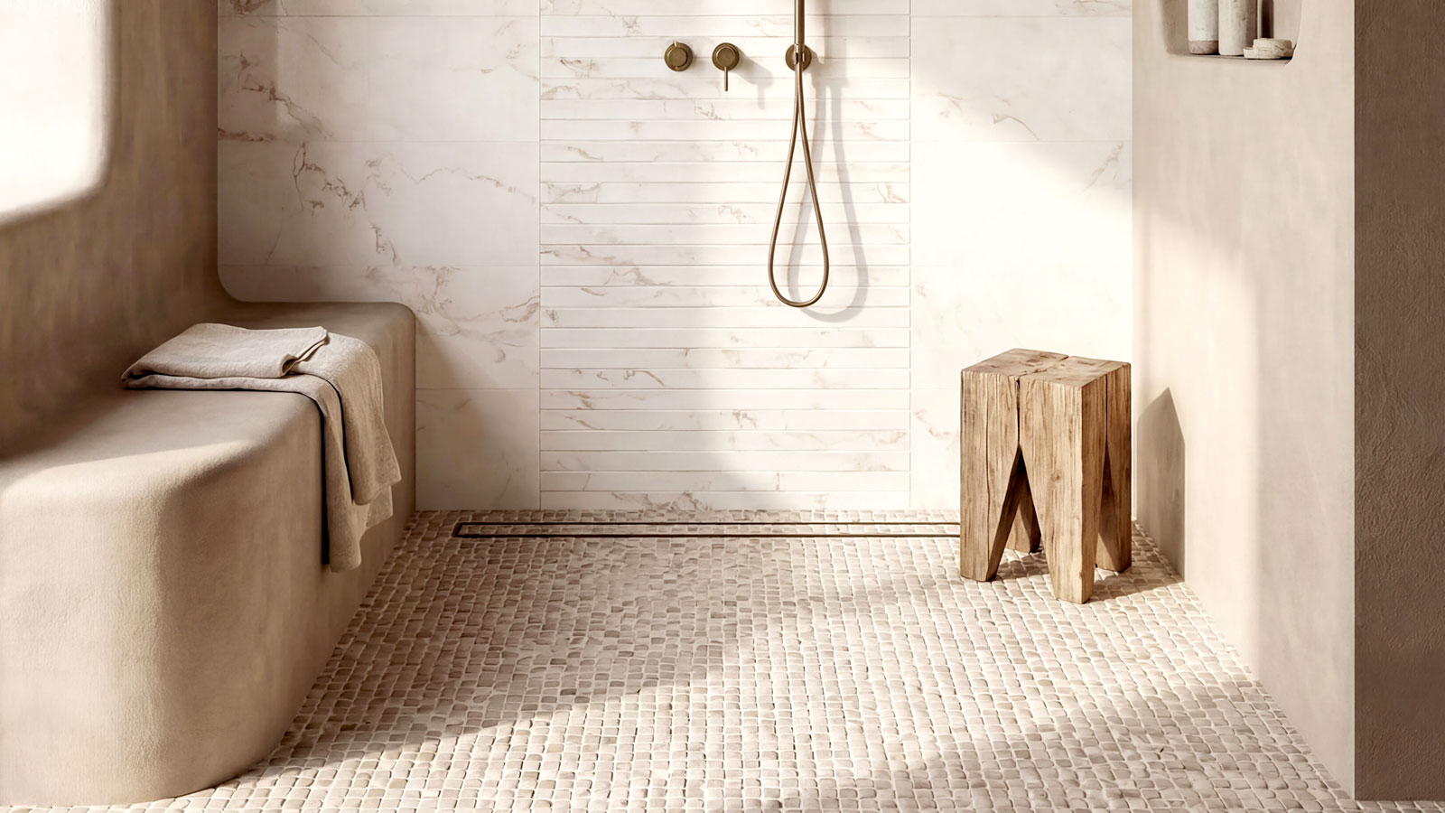 Large wet room with marble wall tiles integrated bench and natural stone mosaic floor tiles with wooden stool in corner