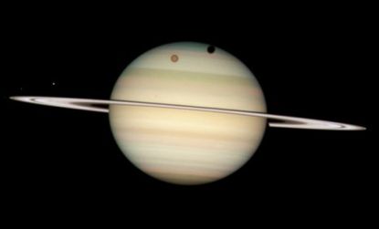 According to NASA, Saturn has four moons, two of which cast a shadow on the planet in the photo taken by the Hubble Space Telescope.