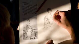 An artist practises drawing using one of the best drawing books