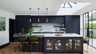 navy kitchen island with lights at one end and roof lantern