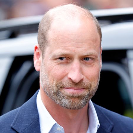 Prince William smirking in front of a car