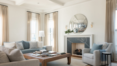 light colored living room with a convex mirror over a fireplace