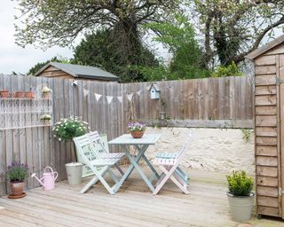 small courtyard with decking and pastel painted furniture