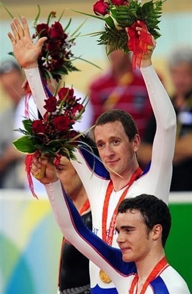 Bradley Wiggins (Great Britain) waves the flowers on top of the Men's 4000m Individual Pursuit final podium.