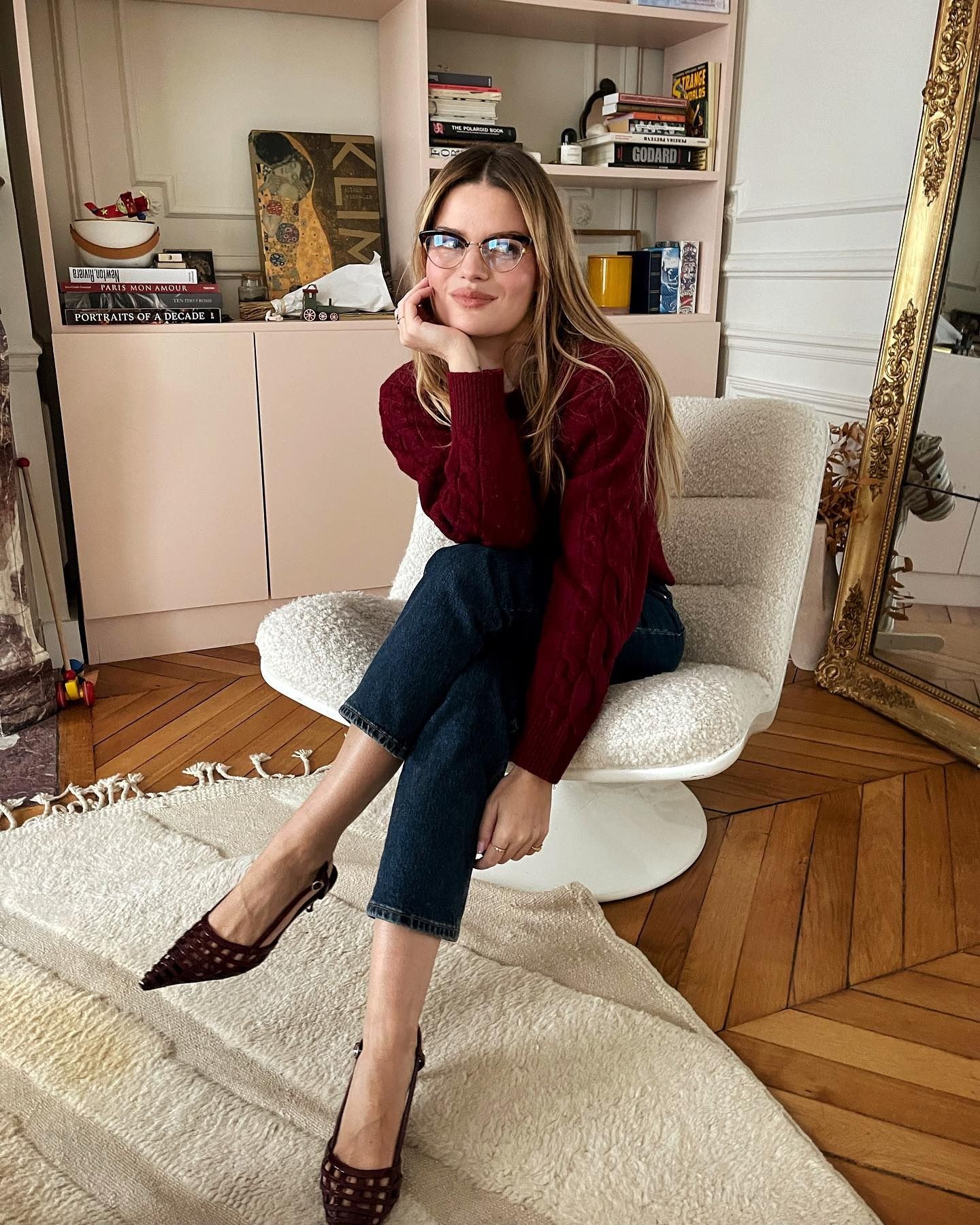 Influencer @sabinasocol wears dark wash slim-fitted jeans with a red jumper and black slingback heels.