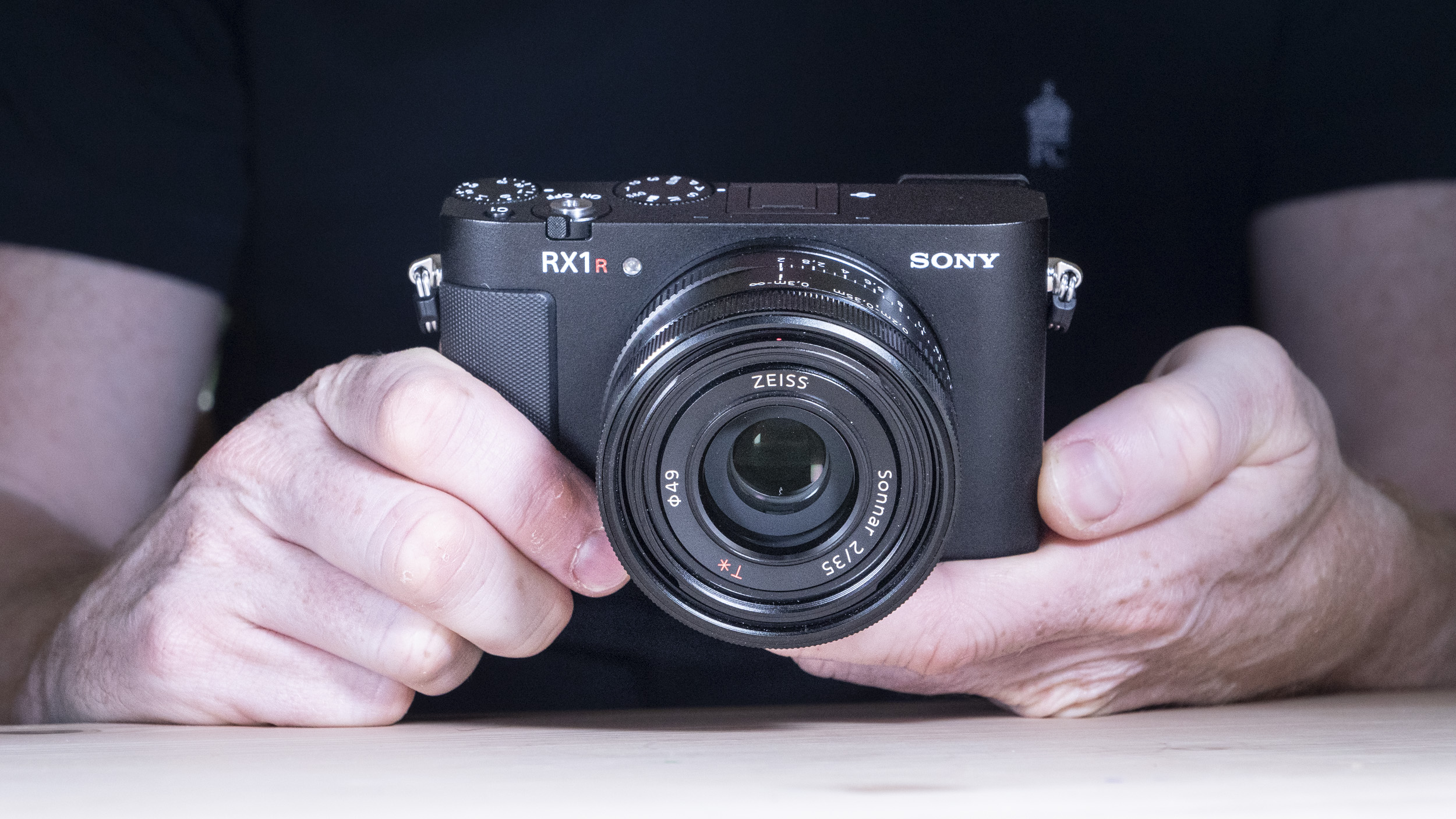 Hands holding the Sony RX1R III compact camera
