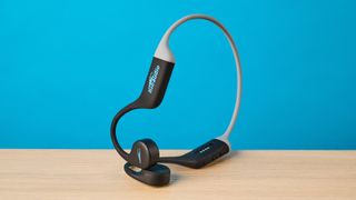 the h2o audio tri run bone conduction headphones photographed against a tom's guide blue background