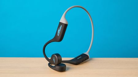 the h2o audio tri run bone conduction headphones photographed against a tom's guide blue background