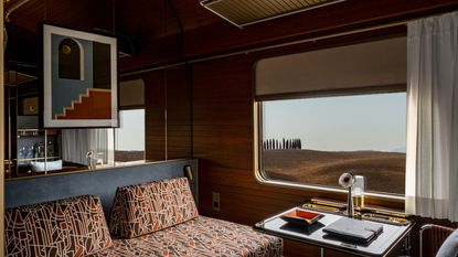 A retro-futuristic train carriage features earthy tones, geometrical patterns, and reflective surfaces, as well as boasting views of the Tuscan countryside.