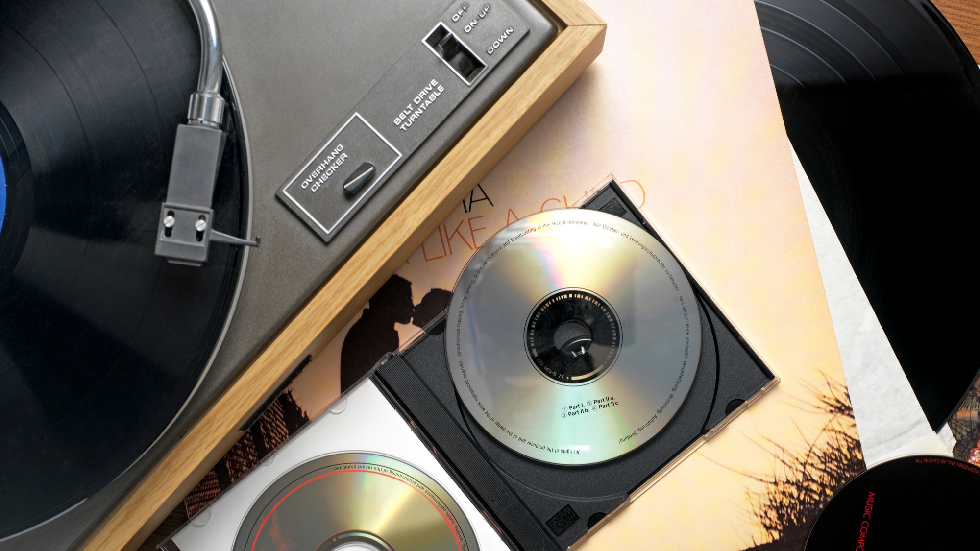 A vintage stereo system with CDs and a record jacket.