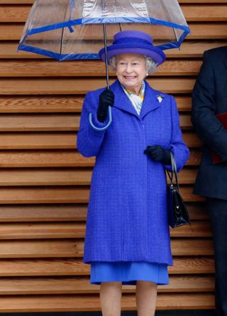 Queen Elizabeth with a blue coat and blue umbrella