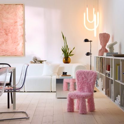 A modern minimalist living room with the IKEA MAMMUT kids' chair covered in the brand's pink faux fur cover from the GREJSIMOJS collection