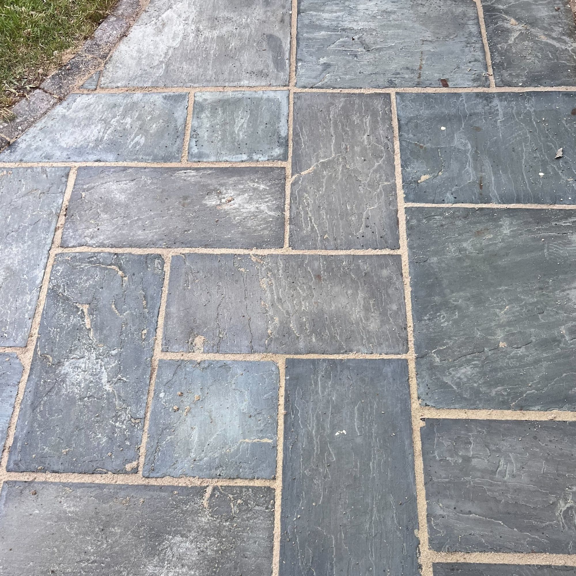 A clean, grey patio with cream grout lines.
