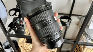 Sony FE 24-70mm f/2.8 GM II lens being held in the hand