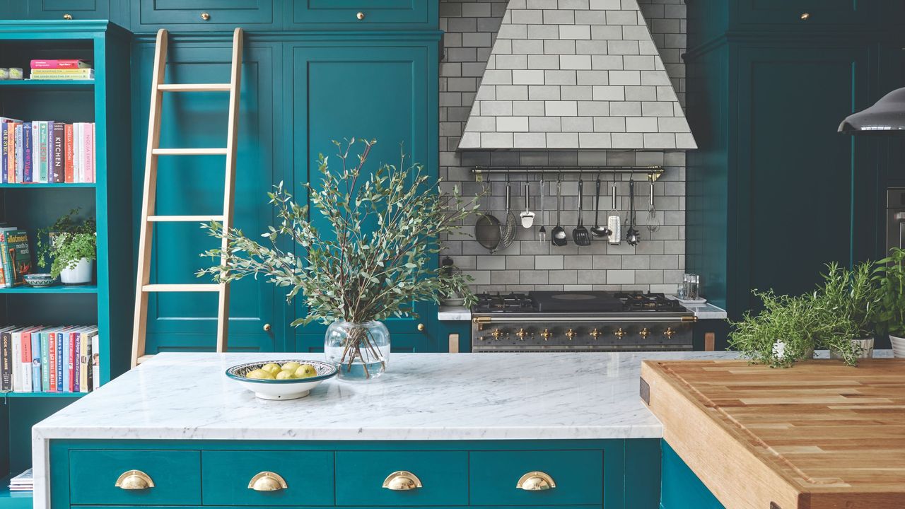 Bold colourful kitchen with light worktops, tiled splashback and extractor hood, and brushed brass handles