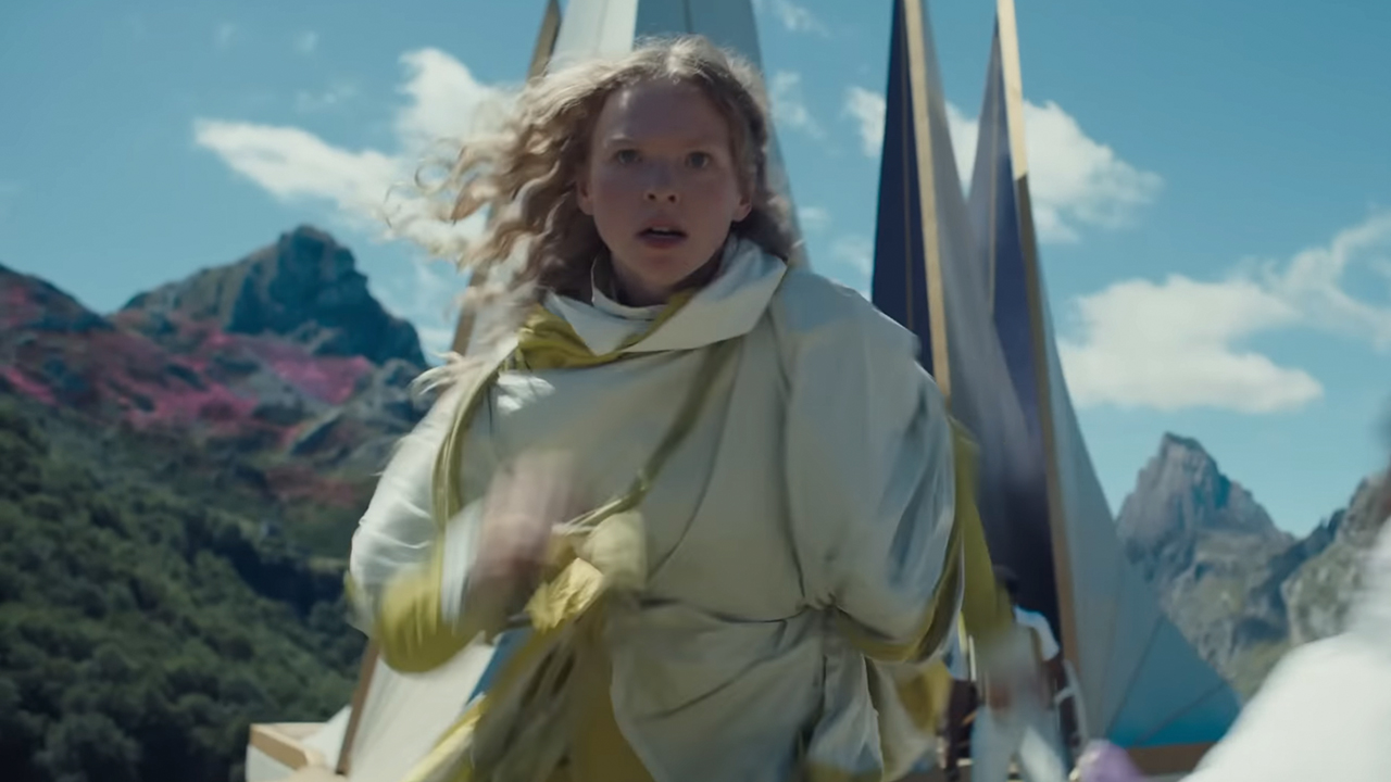 A woman in a white running and looking scared in Sunrise on the Reaping.