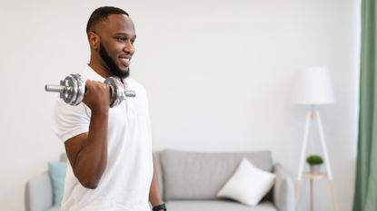 Man working out with dumbbells at home