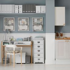 room with white and grey wall and white drawer units and sheve and desk and chair