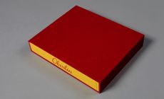 Book encased made with an embossed red twill slipcase