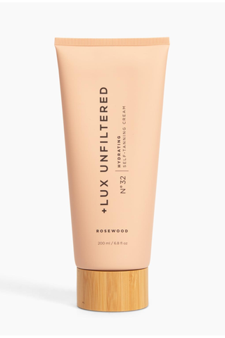 A bottle of +Lux Unfiltered hydrating self-tanning cream set against a white background.