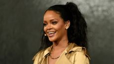 Rihanna smiling wearing a gold top