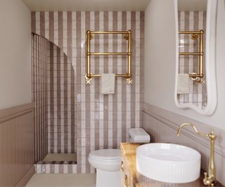 Bathroom with stripe tiles and gold brassware