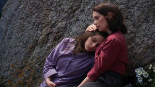 Mrs Coulter cradles a drugged up Lyra as she leans against a giant rock in His Dark Materials season 3