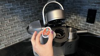 K-Cup being pulled out of open Keurig machine