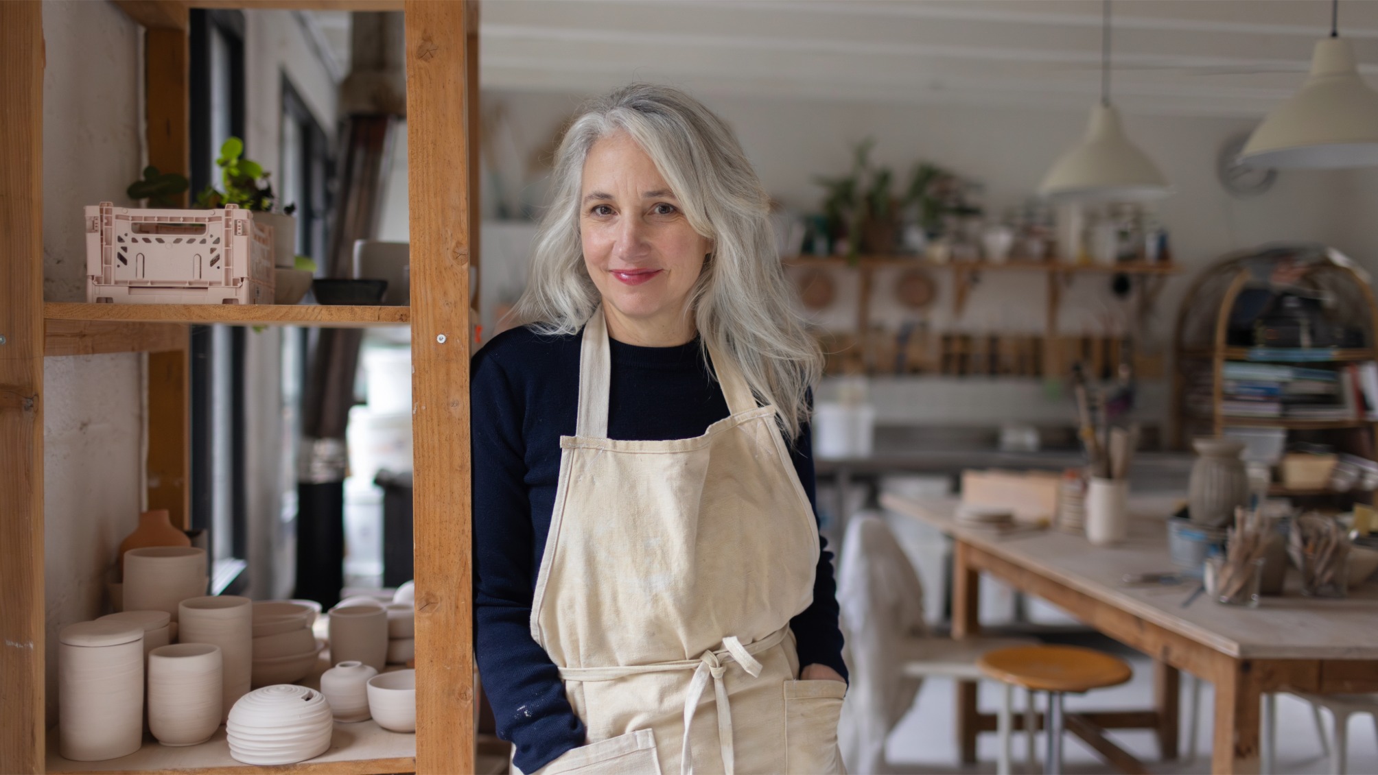 A female ceramicist posing in her studio