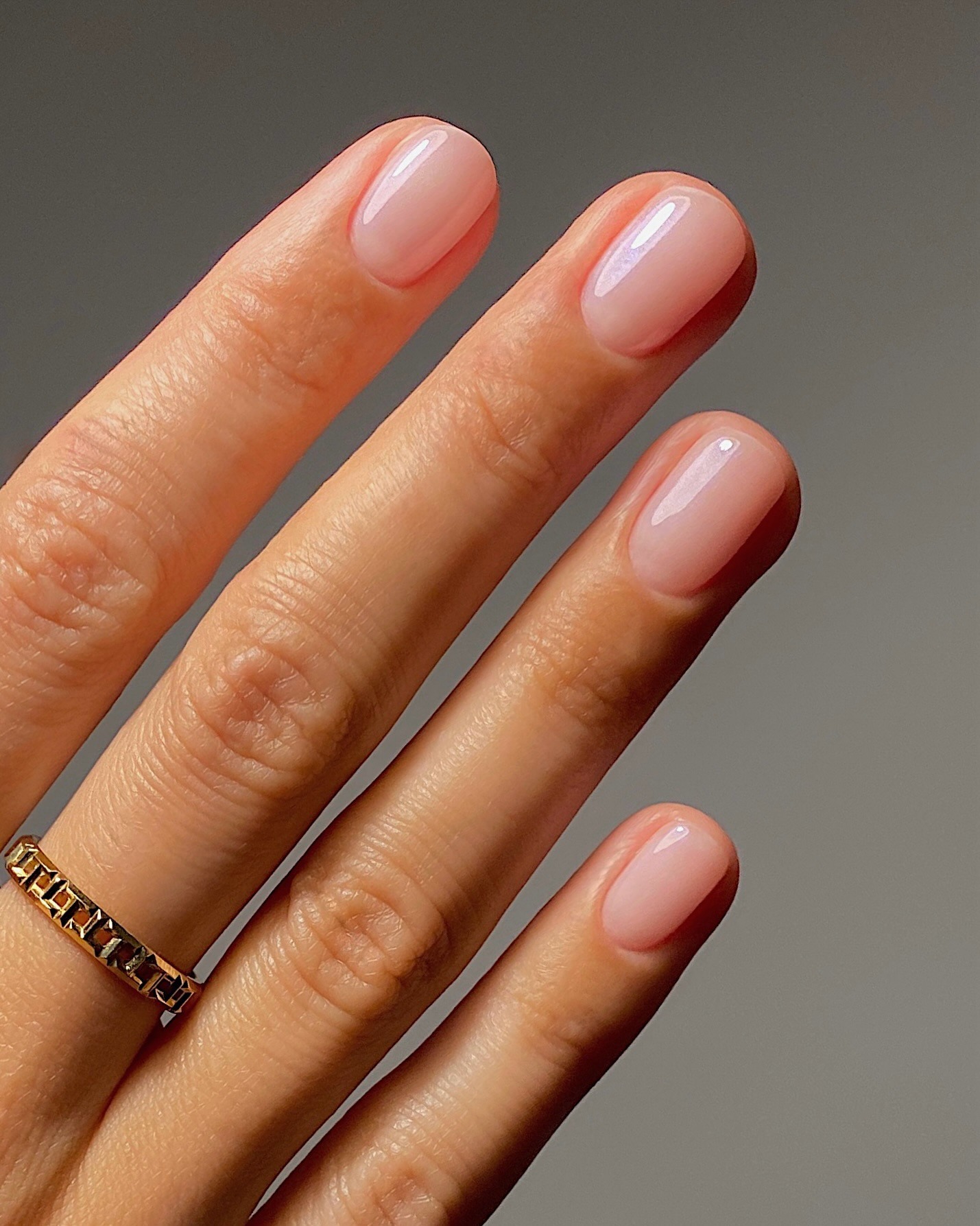 Unghie corte e arrotondate con smalto lattiginoso e brillante