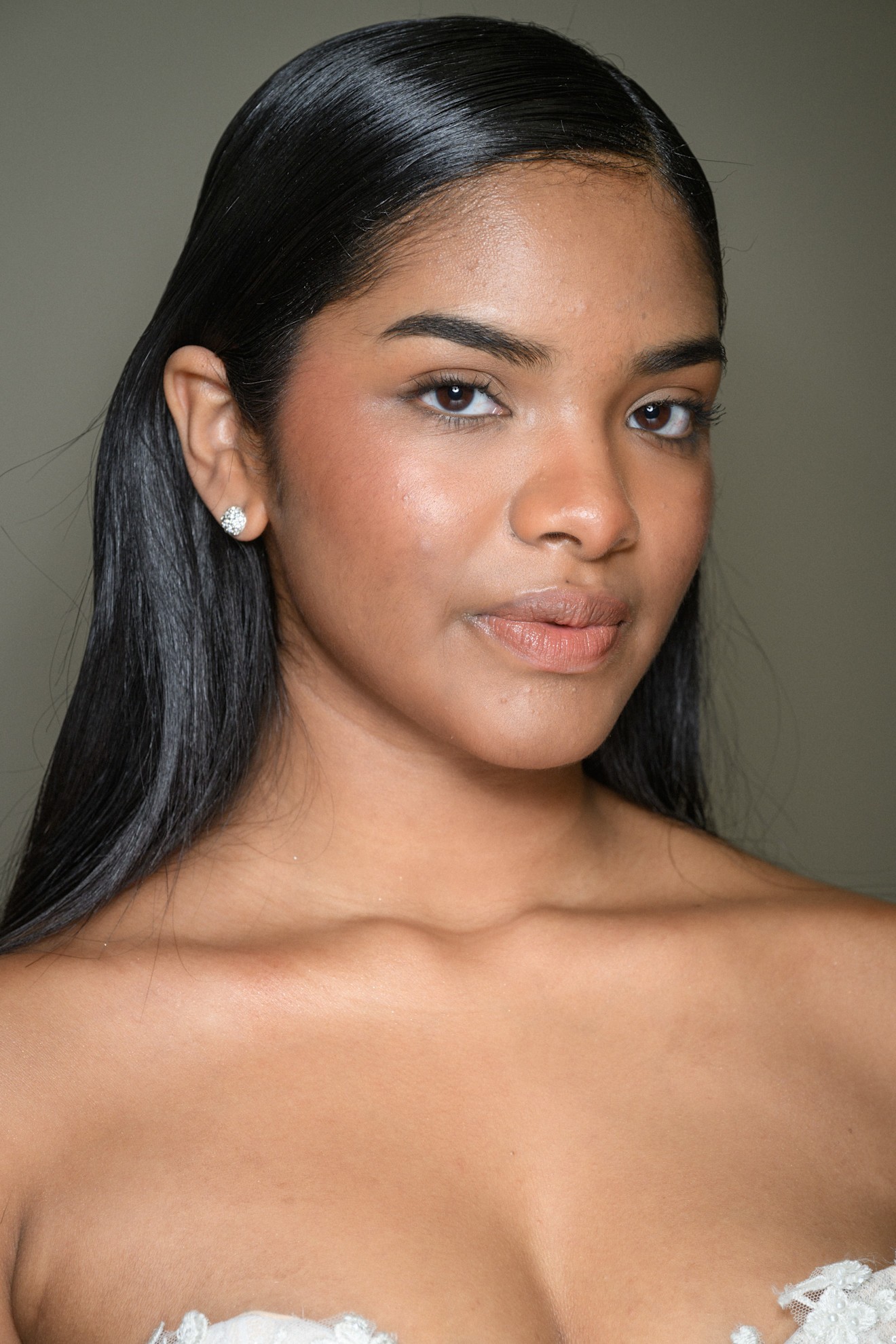 A model with their hair in a sleek and shiny wedding hairstyle