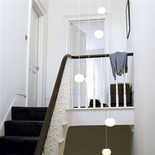 staircase with lighting and white door at top